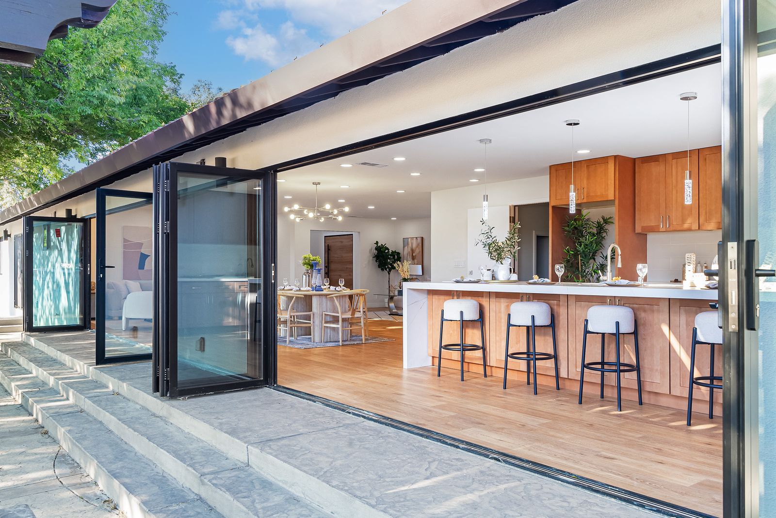 Folding glass wall opening a kitchen and dining area to the patio