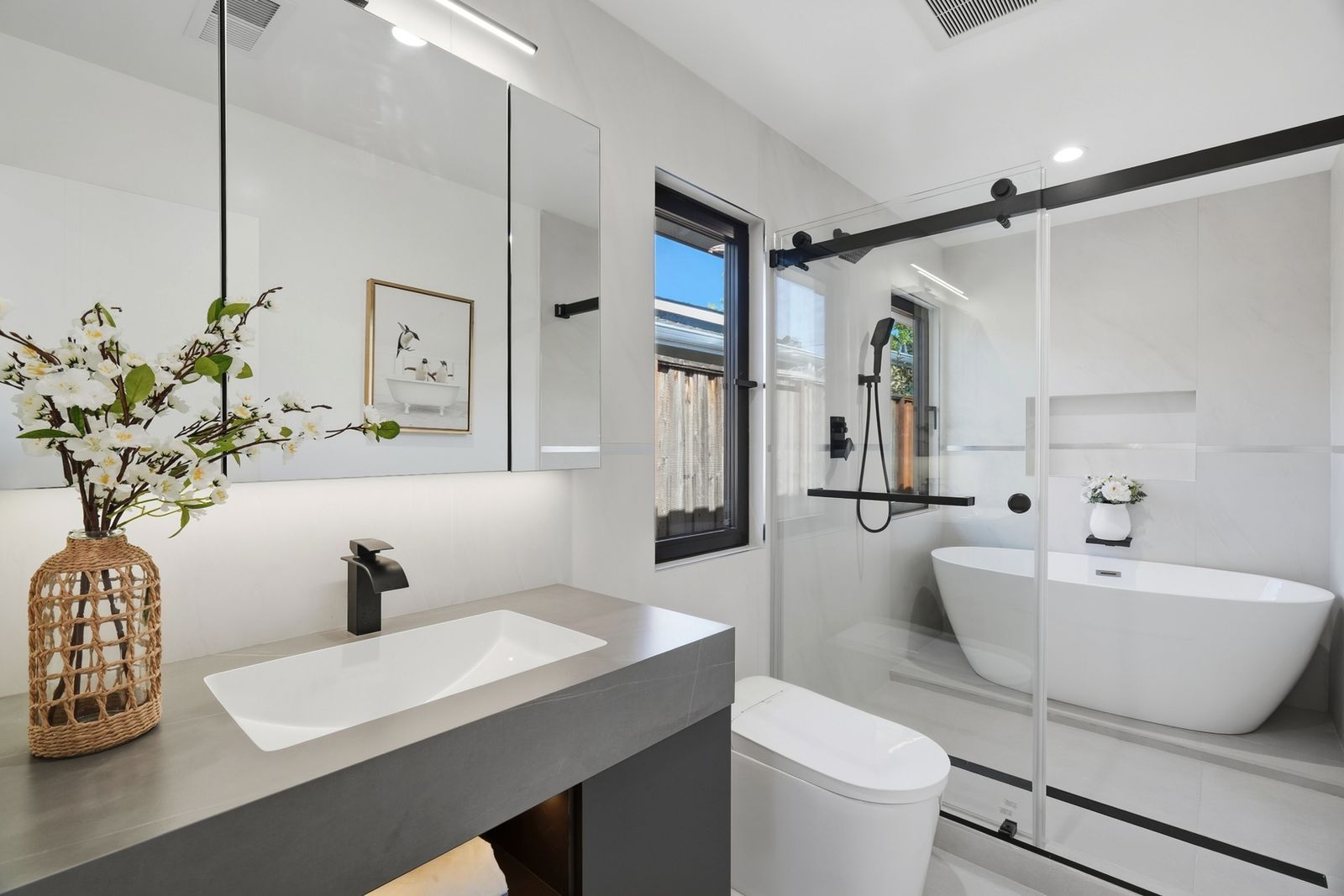 Bathroom with a floating vanity, glass shower and freestanding tub